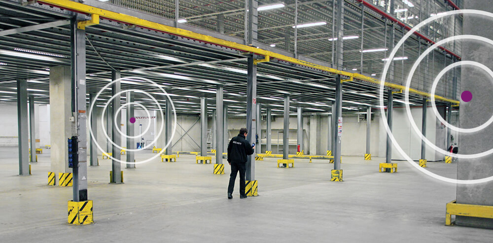 Security officer in a large industrial hall with Bluetooth beacons enabling automated patrols and real-time proof of presence.