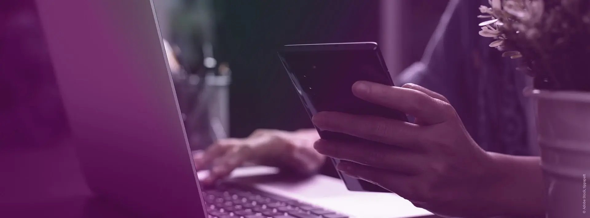 Man_Working_On_Desk_Phone_Handy_Laptop_AdobeStock_426784264_tippapatt